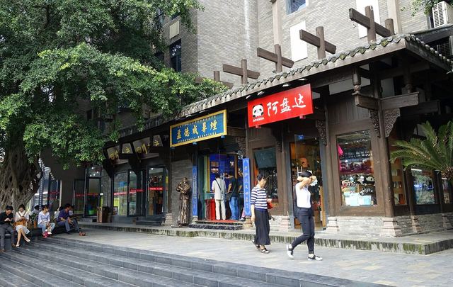 Shaded shopfronts with wooden eaves and red signs along Kuanzhai Alley in Chengdu
